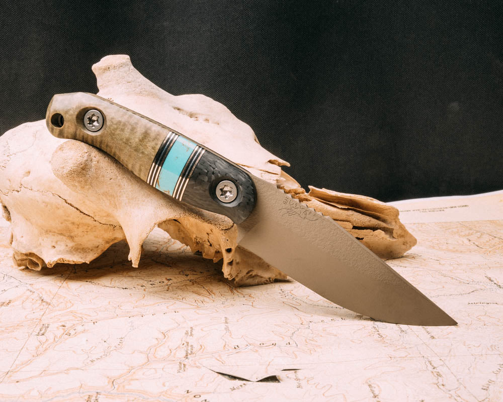 Feather Light- Black carbon, aluminum and black G10 pin striping, Kingman turquoise Tru-stone split, Dyed Curly Maple, FDE cerakote, allen bolts, smooth grip